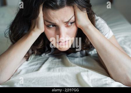 Triste, malheureux femme couché sur le lit dans la dépression. Maux de tête, stress, anxiété, tension, problèmes psychologiques. Mauvaise santé mentale, psychologue visiteur, psycho Banque D'Images