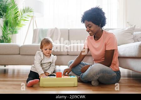 baby-sitter avec bébé jouer avec des jouets Banque D'Images