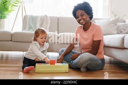 baby-sitter avec bébé jouer avec des jouets Banque D'Images