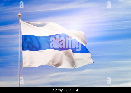 Drapeau blanc bleu blanc sur le mât contre le ciel bleu. Projet de drapeau du mouvement anti-guerre russe et de la république parlementaire. Masque sur le drapeau Banque D'Images