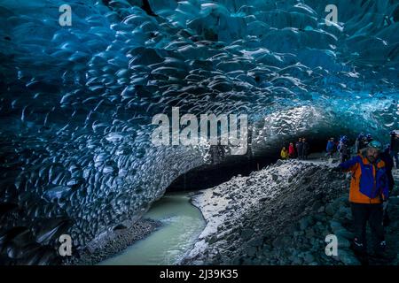 JOKULSARLON,ISLANDE - NOVEMBRE 18 2021: Touristes explorant l'intérieur d'une spectaculaire grotte de glace sous le glacier Vatnajökull dans le sud de l'Islande Banque D'Images