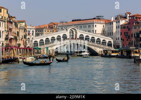 VENISE, ITALIE - 27 2022 MARS : une foule de touristes et de bateaux au célèbre pont du Rialto enjambant le Grand Canal de la ville de Venise Banque D'Images