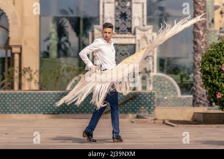 danseur espagnol de flamenco habillé en bleu et blanc déplaçant un manton autour de son corps Banque D'Images