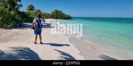 vue arrière d'un photographe prenant des photos sur une plage paradisiaque Banque D'Images