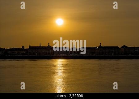 Ciel jaune avec soleil sur le centre de Bordeaux et la Garonne Banque D'Images