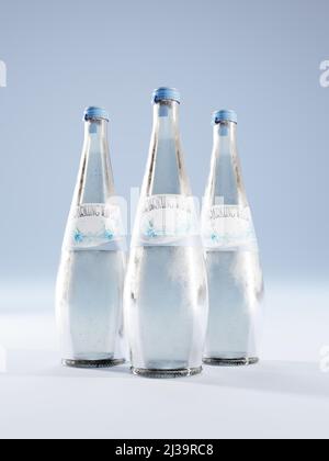 3D rendu de trois bouteilles d'eau étincelante en verre avec fausse étiquette sur fond bleu Banque D'Images