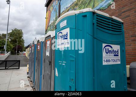 Woodinville, WA USA - vers septembre 2021: Vue sur la rue d'une ligne de port-a-potties dans le centre-ville, par une journée nuageux. Banque D'Images