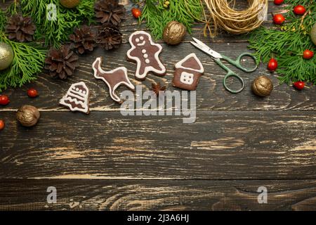 Noël, nouvel an. Cartes postales à poser à plat, jouets étincelants, biscuits, cône de pin sur une table en bois, noix, vue du dessus, espace de copie. Bannière Banque D'Images