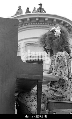 Des gens sur le toit d'un bâtiment victorien regardant un musicien se produire au Haight Ashbury Street Festival à San Francisco, CA Banque D'Images