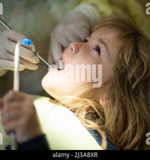 Petit garçon avec une bouche ouverte examinant l'inspection dentaire au cabinet de dentiste. Les dentistes mains avec des outils dentaires. Des dents saines, concept. Banque D'Images