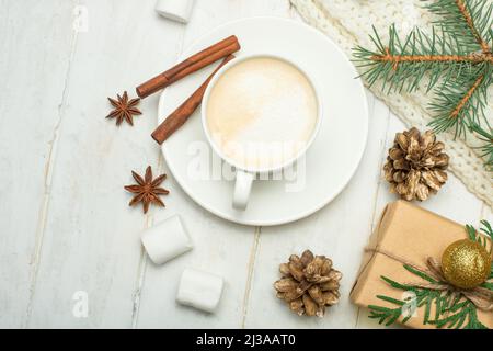 Composition de Noël de style scandinave. Cadeaux de Noël, café avec guimauves, cônes de pin, branches d'épicéa sur fond blanc en bois. Plat Banque D'Images