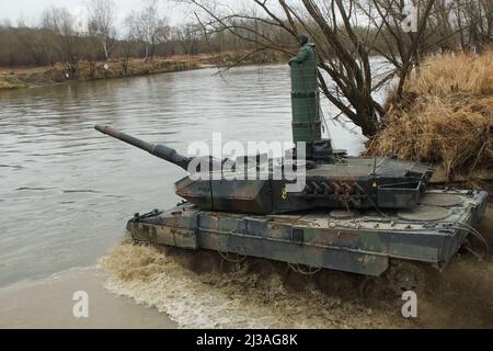 Un char polonais Leopard 2 traverse une rivière tout en étant couvert par des parachutistes américains lors d'un exercice d'entraînement combiné près de Zamosc, Pologne, mars 31. L'équipe de combat de 3rd Brigade, 82nd Airborne Division, est déployée en Pologne pour soutenir le Commandement européen des États-Unis afin d'assurer nos alliés de l'OTAN. (É.-U. Photo de l'armée par Sgt. Garrett Ty Whitfield) Banque D'Images