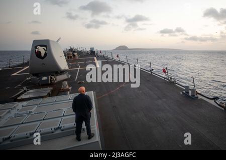 220403-N-KW492-1061 MER DES PHILIPPINES (le 3 avril 2022) le chef principal de la lutte contre les incendies Erik Kuntzleman, de Las Vegas, observe que le destroyer de missiles guidés de la classe Arleigh Burke USS Milius (DDG 69) transite par Iwo. Autrefois appelé Iwo Jima, le Japon est revenu à l'appeler par son nom d'avant-guerre en 2007. Milius est affecté au Destroyer Squadron (DESRON) 15, le plus grand DESRON déployé à l’avant de la Marine et à la principale force de combat de la flotte américaine 7th, et est en cours d’appui à une Indo-Pacific libre et ouverte. (É.-U. Navy photo par Mass communication Specialist 2nd Class Ryre Arciaga) Banque D'Images