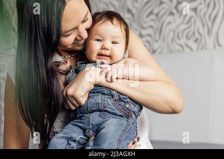 Portrait de mère heureuse avec petite fille dans la chambre à coucher gros plan, espace libre de copie, arrière-plan flou. Embrassez le bébé insatisfaction, capturez la nature Banque D'Images