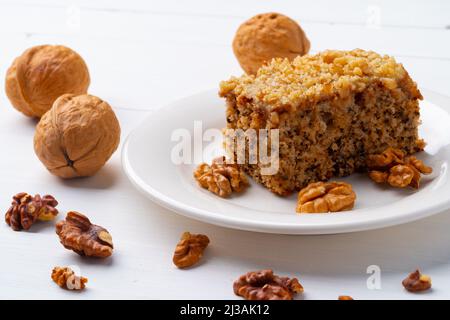 Morceau de gâteau aux noix sur la plaque blanche Banque D'Images