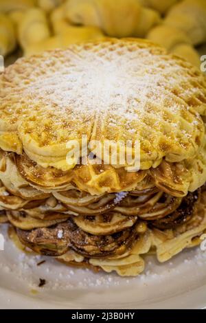 Une pile de gaufres avec garniture en poudre de sucre sur une table de buffet Banque D'Images