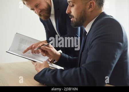 Des collègues sérieux d'avocats lisent ensemble des documents juridiques et étudient des informations sur les nouvelles affaires juridiques. Banque D'Images