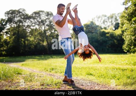 Portrait d'un père noir heureux portant sa fille à l'extérieur.Famille bonheur amour concept. Banque D'Images