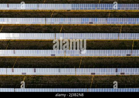 Gros plan symétrique des panneaux solaires d'un système photovoltaïque sur un parc solaire en Allemagne du point de vue d'un drone Banque D'Images