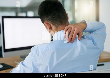 Une mauvaise posture a un effet néfaste. Photo d'un jeune homme d'affaires tenant le cou tout en étant assis à son bureau. Banque D'Images