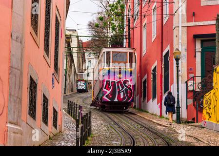 Lisbonne, très raide Tram de Gloria Restauradores. Graffiti sur la voiture de transport en commun et maisons colorées Banque D'Images