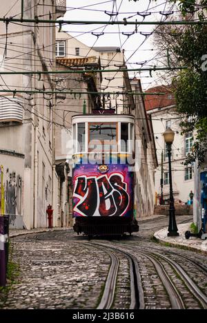 Lisbonne, très raide Tram de Gloria Restauradores. Graffiti sur la voiture de transport en commun et maisons colorées Banque D'Images