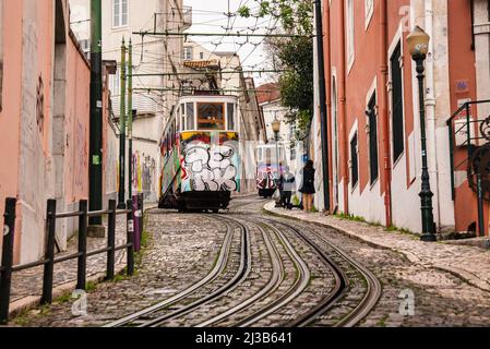 Lisbonne, très raide Tram de Gloria Restauradores. Graffiti sur la voiture de transport en commun et maisons colorées Banque D'Images