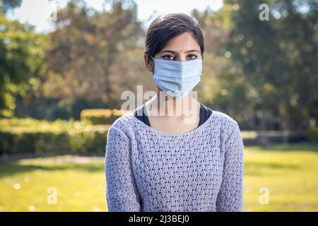 Adolescente indienne jeune femme portant un masque facial à l'extérieur pendant la pandémie du coronavirus COVID-19. Banque D'Images