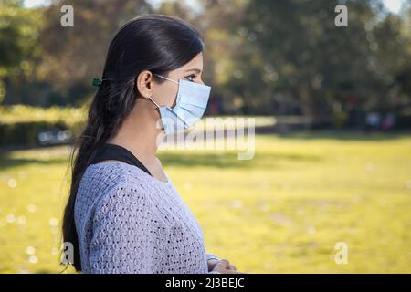 Indien adolescent fille jeune femme portant un masque facial à l'extérieur pendant le coronavirus. Banque D'Images