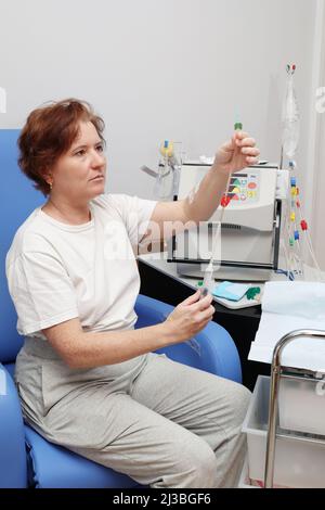 femme blanche se préparant à l'hémodialyse à domicile Banque D'Images