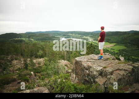 Randonneur debout sur le rocher et regardant la vue Banque D'Images