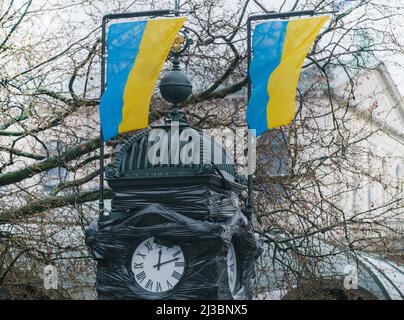 Hanovre, Allemagne. 07th avril 2022. À l'horloge de la Kröpcke, qui est couverte en noir à cause de la guerre d'Ukraine, deux drapeaux de l'Ukraine volent peu après douze. Crédit : OLE Spata/dpa/Alay Live News Banque D'Images