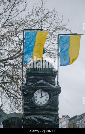 Hanovre, Allemagne. 07th avril 2022. À l'horloge de la Kröpcke, qui est couverte en noir à cause de la guerre d'Ukraine, deux drapeaux de l'Ukraine volent peu après douze. Crédit : OLE Spata/dpa/Alay Live News Banque D'Images