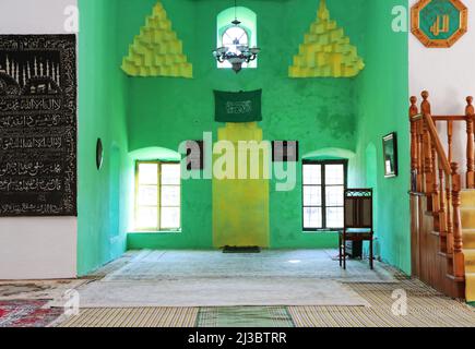 Une belle photo de l'intérieur d'une ancienne mosquée avec le drapeau vert de l'Arabie Saoudite sur le mur vert et jaune Banque D'Images