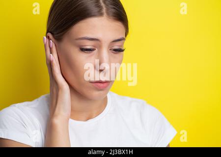 Gros plan sur le profil latéral malade femme ayant des douleurs d'oreille touchant sa tête douloureuse Banque D'Images