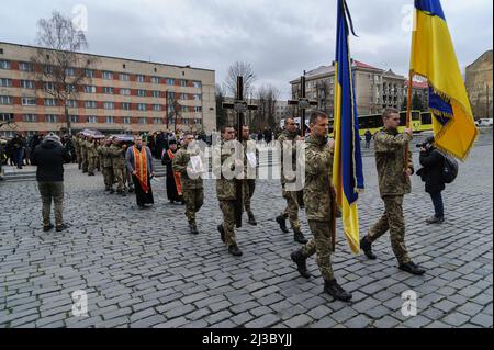 Lviv, Ukraine. 06th avril 2022. Les militaires ukrainiens portent les drapeaux ukrainiens crucifix et les coffres des trois soldats tombés lors de la cérémonie funéraire. Service funéraire de trois soldats ukrainiens, Liubomyr Gudzelyak, le sergent Vyacheslav Ubiyvovk et Ruslan Koval, tués par les forces russes dans le cadre de l'invasion de l'Ukraine par la Russie. Crédit : SOPA Images Limited/Alamy Live News Banque D'Images