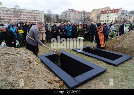 Lviv, Ukraine. 06th avril 2022. Les prêtres couvrent les tombes des soldats avec du sol lors de la cérémonie funéraire de 3 soldats ukrainiens. Service funéraire de trois soldats ukrainiens, Liubomyr Gudzelyak, le sergent Vyacheslav Ubiyvovk et Ruslan Koval, tués par les forces russes dans le cadre de l'invasion de l'Ukraine par la Russie. Crédit : SOPA Images Limited/Alamy Live News Banque D'Images