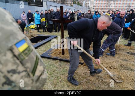 Lviv, Ukraine. 06th avril 2022. Les gens couvrent les tombes des soldats avec du sol lors de la cérémonie funéraire de 3 soldats ukrainiens. Service funéraire de trois soldats ukrainiens, Liubomyr Gudzelyak, le sergent Vyacheslav Ubiyvovk et Ruslan Koval, tués par les forces russes dans le cadre de l'invasion de l'Ukraine par la Russie. Crédit : SOPA Images Limited/Alamy Live News Banque D'Images