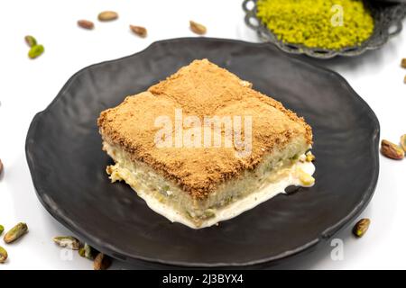 Baklava froide sur fond blanc. Le baklava froid préparé avec du lait et de la pistache est très populaire. Cuisine méditerranéenne traditionnelle. Fermer Banque D'Images