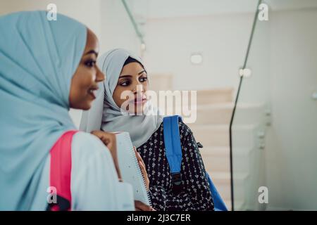 Une photo de deux étudiantes musulmanes africaines avec un sac à dos dans une maison moderne. Banque D'Images