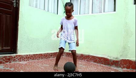 Enfant africain jouant avec le ballon, enfant noir de jeune garçon joue le sport par lui-même Banque D'Images