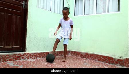 Enfant africain jouant avec le ballon, enfant noir de jeune garçon joue le sport par lui-même Banque D'Images