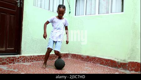 Enfant africain jouant avec le ballon, enfant noir de jeune garçon joue le sport par lui-même Banque D'Images