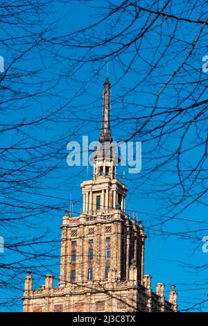 Haut du bâtiment de l'Académie lettone des sciences à Riga, en Lettonie, derrière les branches d'arbres Banque D'Images