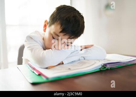 Penser enfant s'ennuyer et frustré et a nourri de faire ses devoirs Banque D'Images