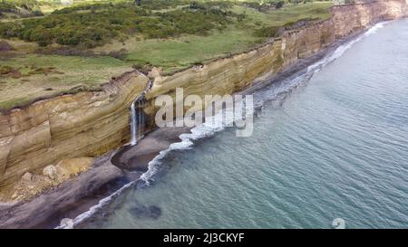 Vue aérienne de la chute d'eau sur la falaise de Golovinsky sur l'île de Kunashir, les îles Kuril, Russie. Banque D'Images