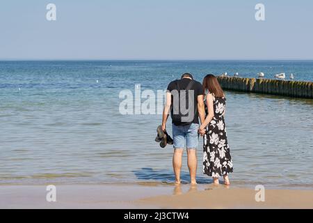 Jeune couple marchant sur la plage de la mer Baltique près de Kolobrzeg en Pologne Banque D'Images