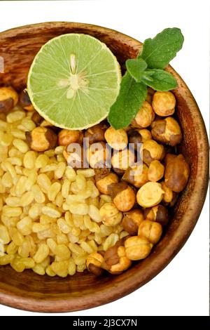 fermer les lentilles frit de gramme jaune avec du gramme noir et des tranches de citron, menthe dans le bol en bois rouge sur fond blanc hors foyer. Banque D'Images