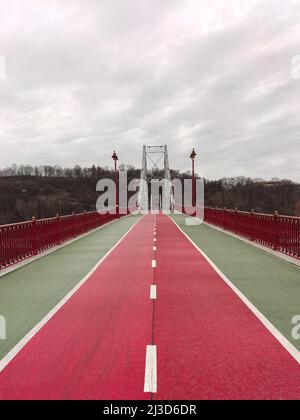 Asphalte route divisée de couleur rouge sur le pont en perspective. Lampadaires sur les côtés Banque D'Images