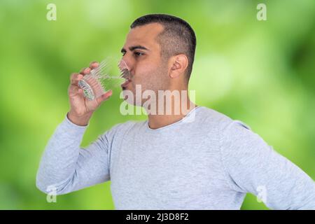 Photo en gros plan de l'eau potable de l'homme sportif à la peau brune. Concept de consommation quotidienne d'eau ou de consommation d'eau pour la santé Banque D'Images